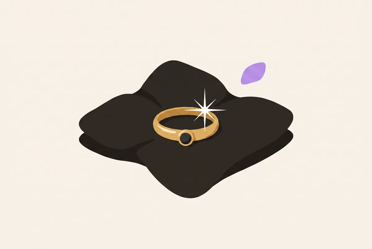 Cincin yang baru dipoles di atas kain gelap memantulkan titik cahaya terang.